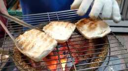 烤饅頭做成土味漢堡，饅頭掰開放爐火上烤熟抹芝麻醬夾芝士和牛肉